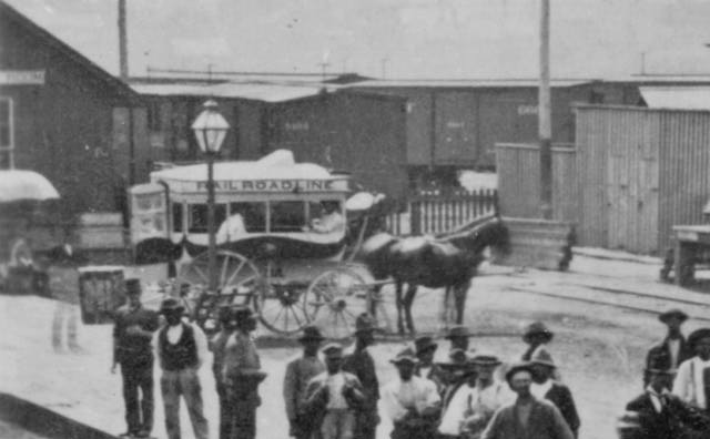 Far left background, horse and buggy.