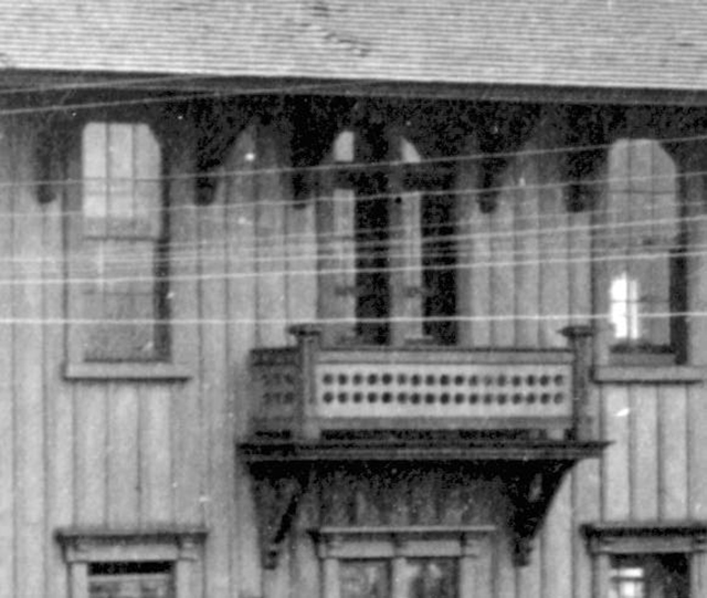 Detail of second story above entry on right.