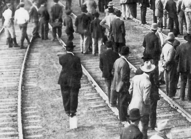 Man standing on concrete post at left