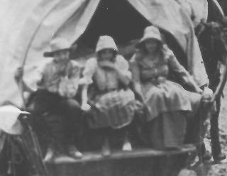 Three people in wagon on left