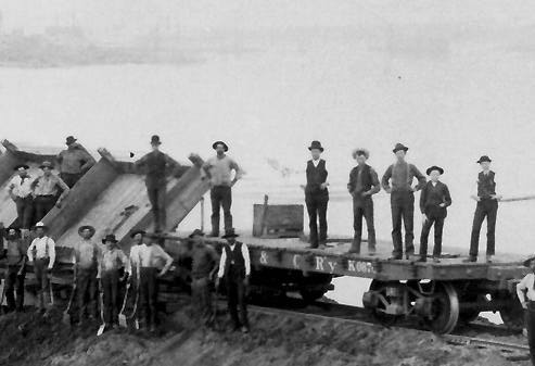 Men standing on flatcar.